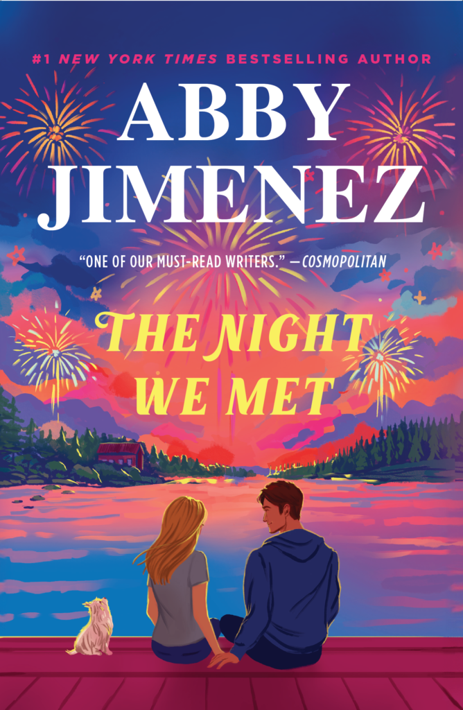 The cover for "The Night We Met" by Abby Jimenez features a couple sitting on a wooden dock, looking out over a calm, starry night sky with a dog sitting beside them.